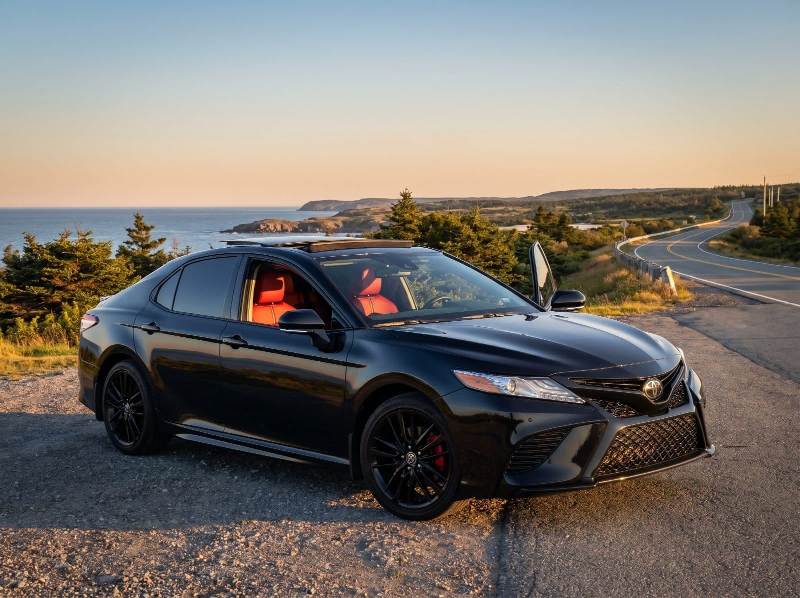 Black Toyota Camry XSE parked on a Nova Scotia coastal road